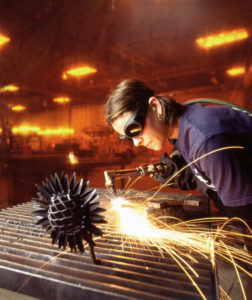 Torch Welding W/ Welding Curtain Behind Worker