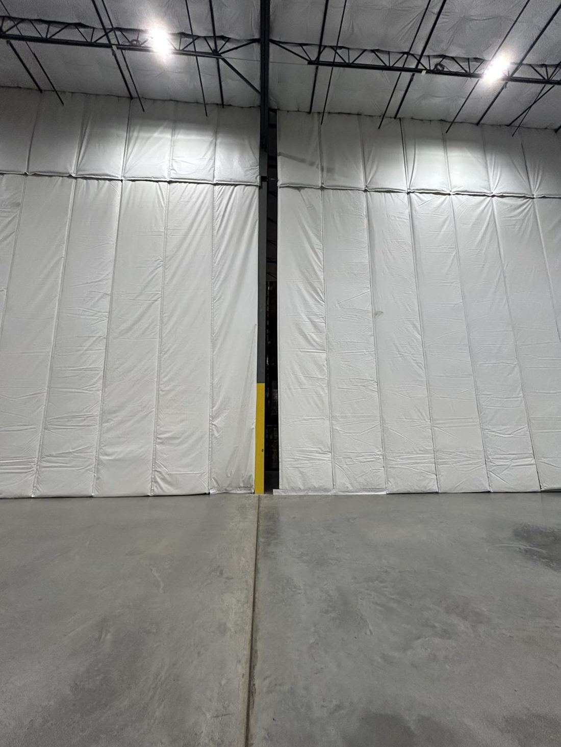 Insulated Curtain Panels Meeting At A Building Column, With The Yellow Column Guard Visible In The Gap
